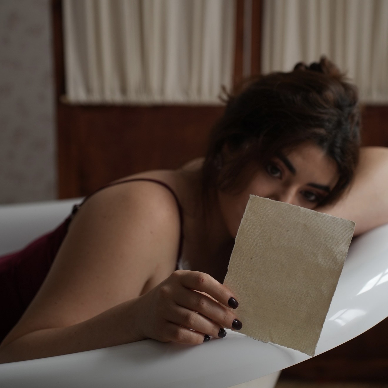 Leeza Maroe holding a paper card to her face