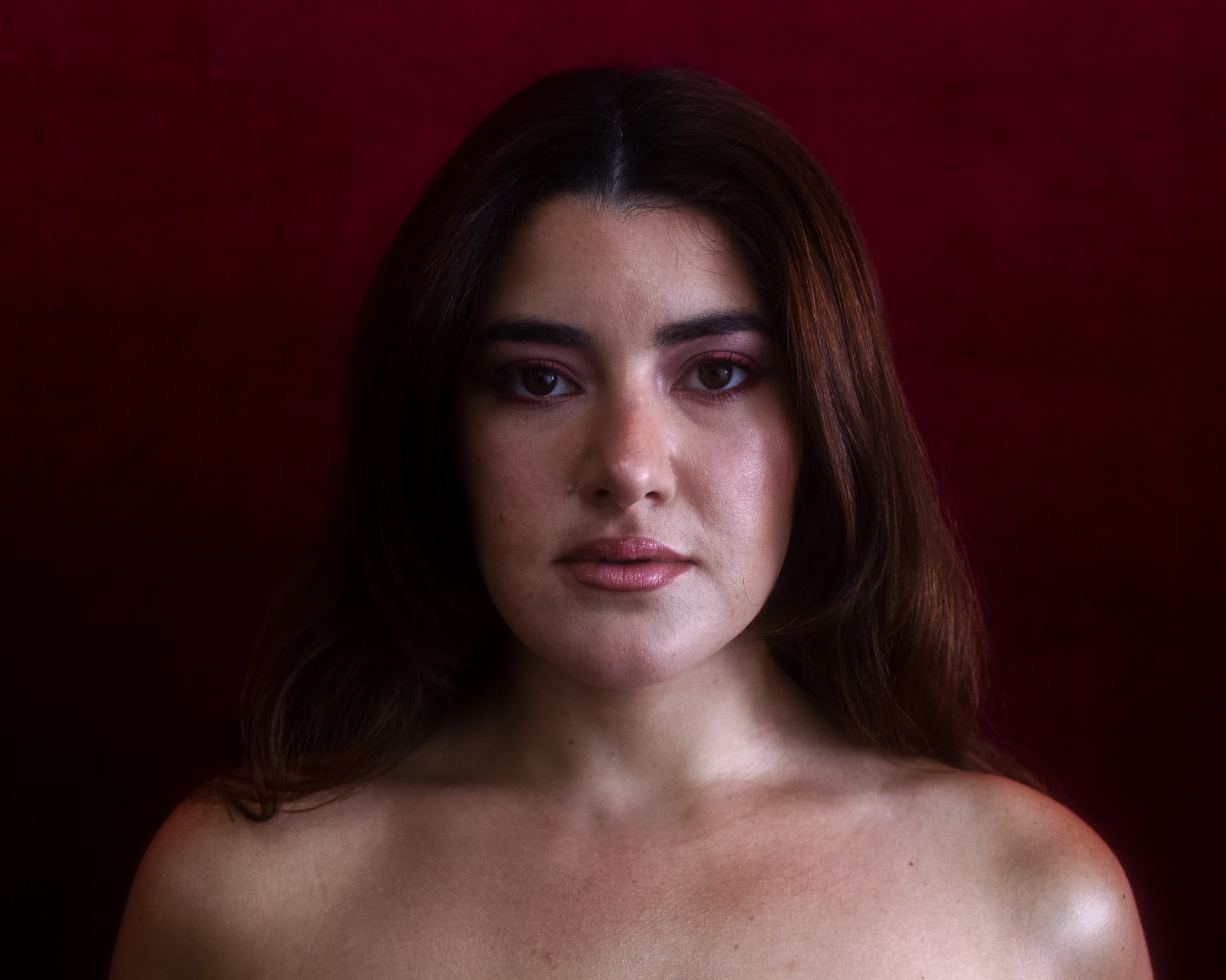 Portrait of Leeza Maroe against a deep red backdrop